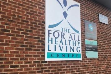 The 'For All Healthy Living Centre' sign on a brick wall.