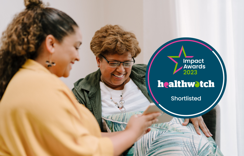 Two people sitting on a sofa, looking at a tablet. Over the image is a dark blue roundel. White, pink and green text on the roundel reads: 'Impact Awards 2023' - 'Healthwatch' - 'Shortlisted'