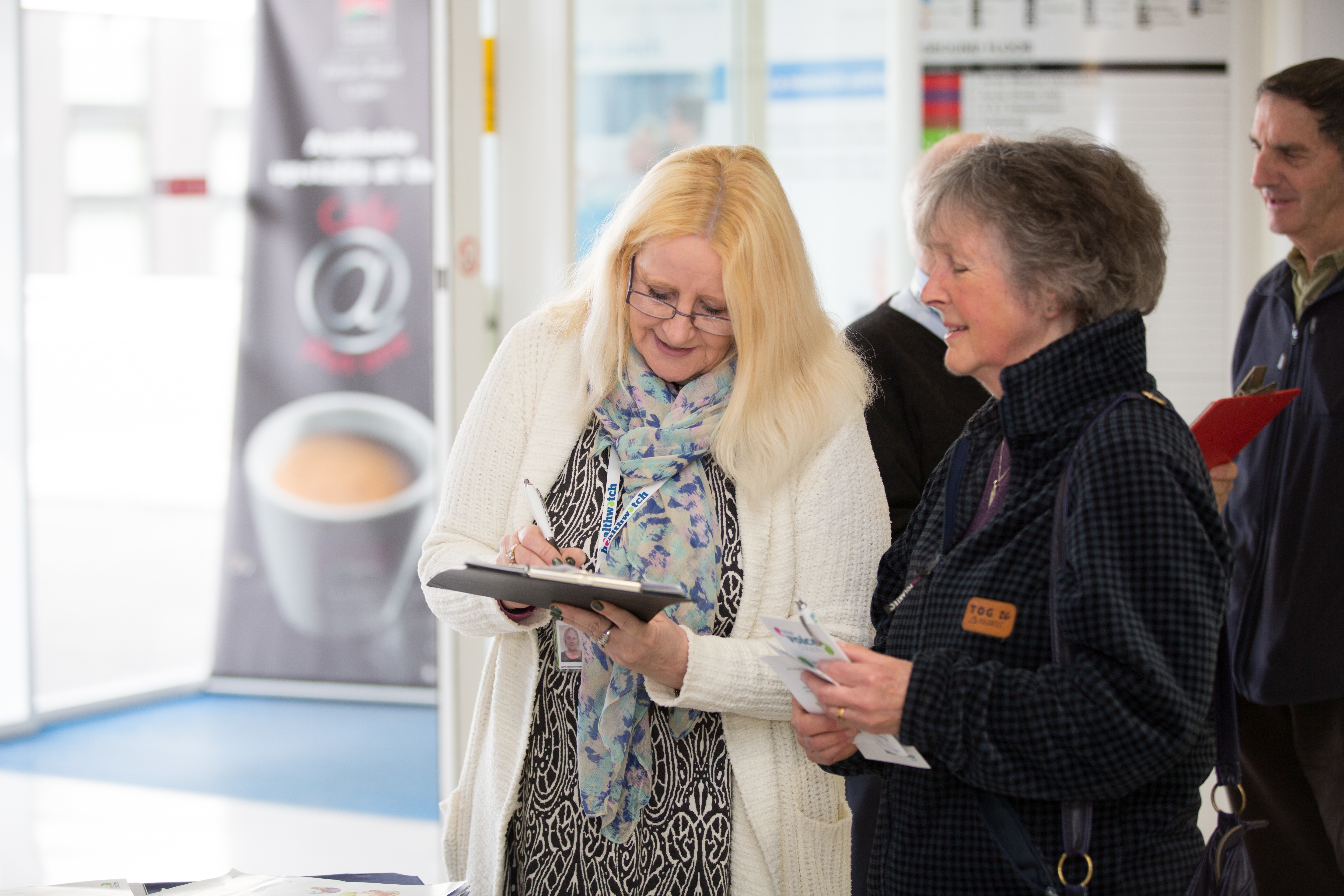 Woman filling in a form on behalf of the other lady