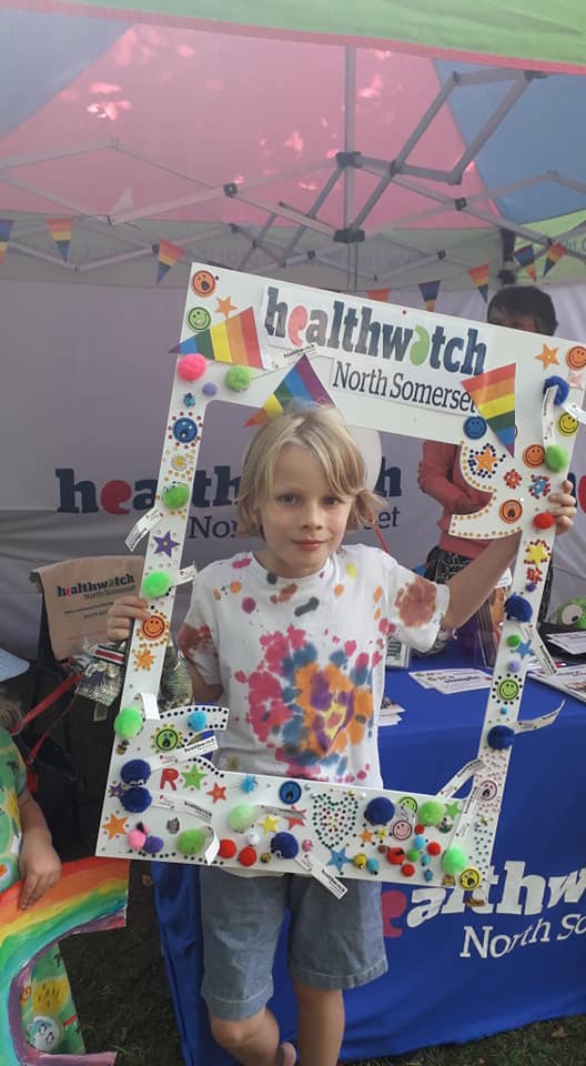 Young boy standing in selfie frame at Pride