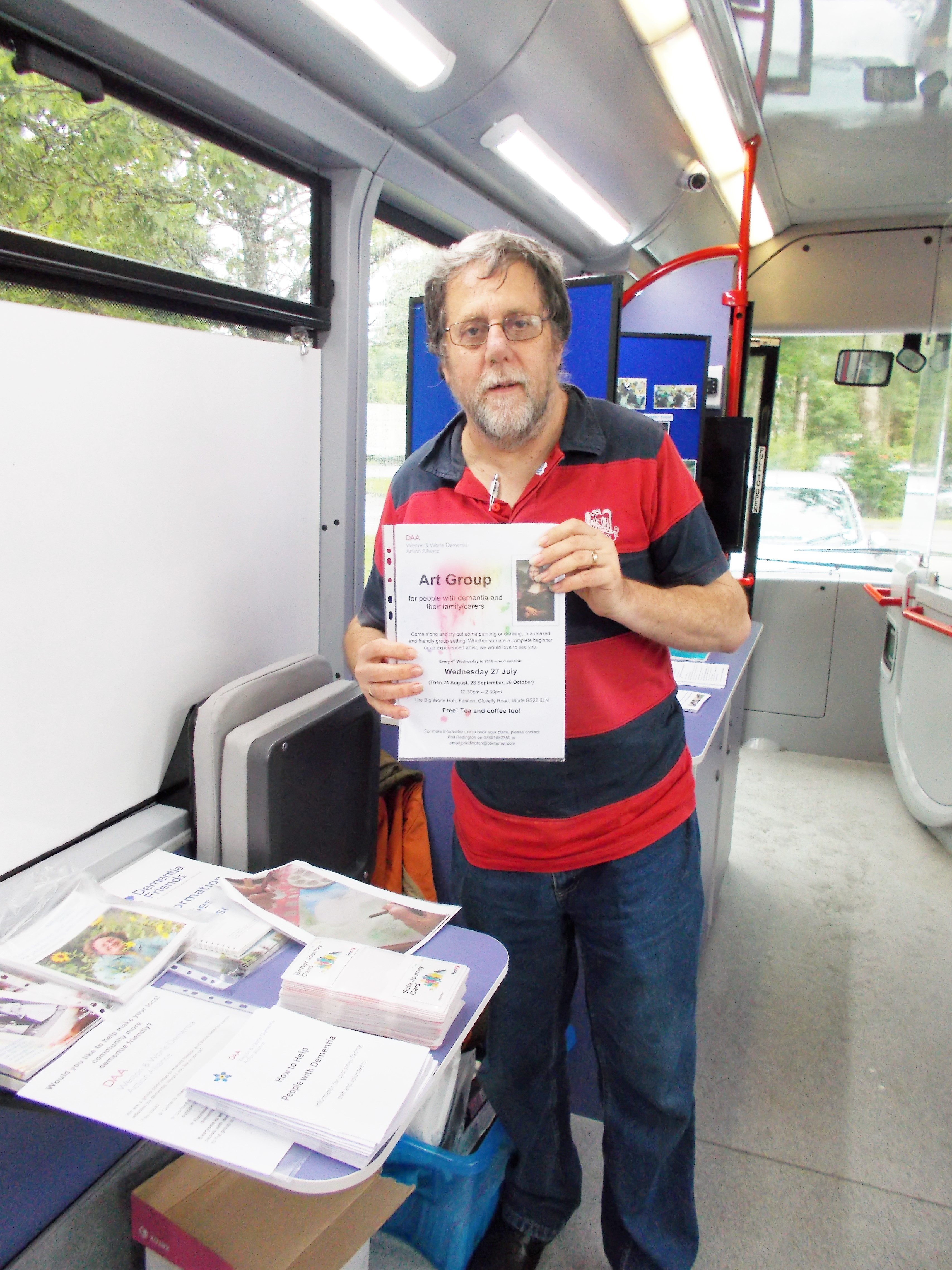 Volunteer holding a Healthwatch sign on board the bus