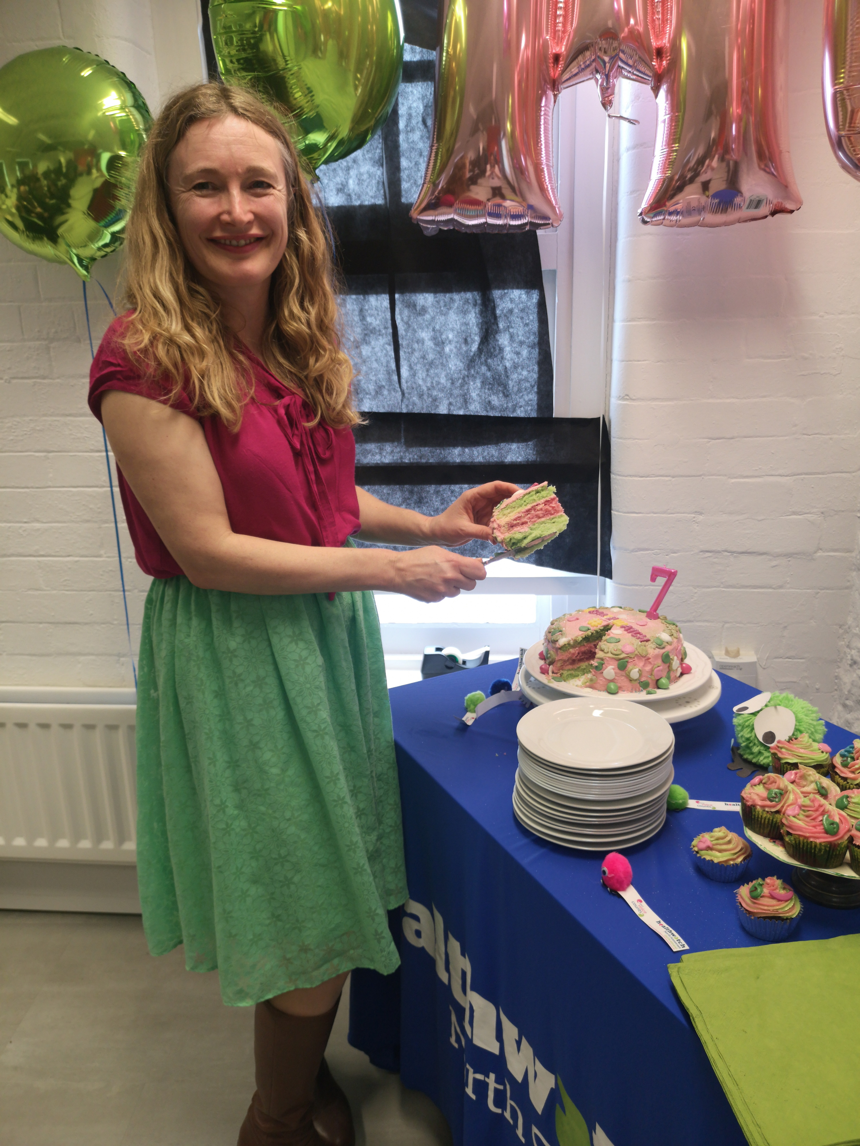 Rebecca cutting Healthwatch's birthday cake