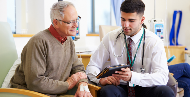 A doctor showing a patient some information on a tablet.