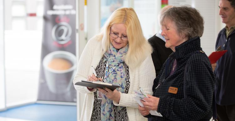 Doctor wearing a white coat speaking to a patient