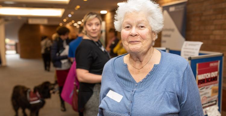 Elderly woman smiling at an event