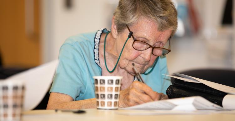 Elderly woman filling in a form