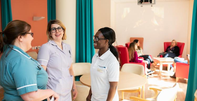 Three nurses talking on a hospital ward