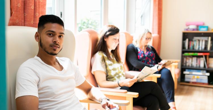 Young lad and two women sitting in a hospital day room