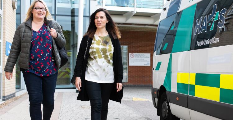Two women walking into a hospital together