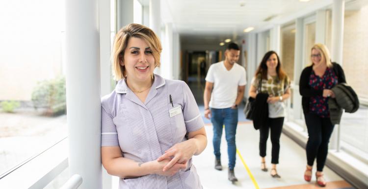 Nurse standing in a busy corridor