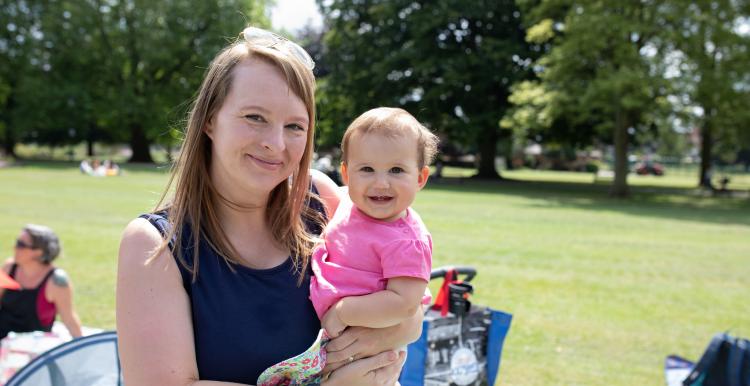 Mum at a breastfeeding picnic with her baby in her arms