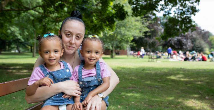 Young mum with twins sitting on her knee