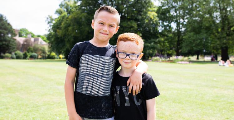 Two young boys standing with their arm round each other