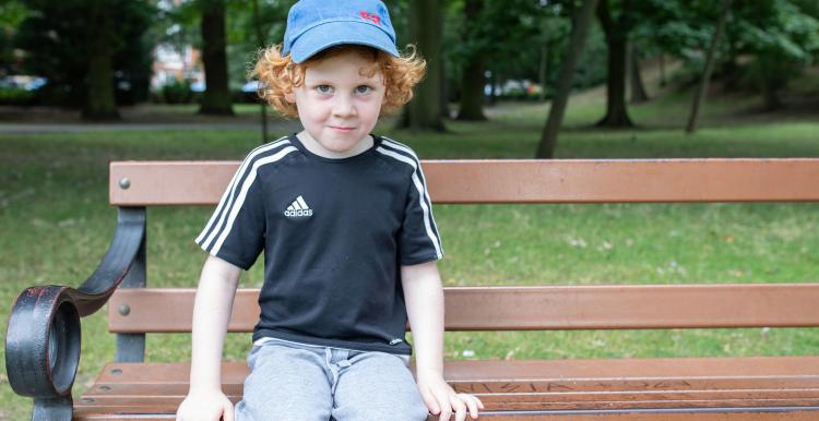 Young boy sitting on a park bench