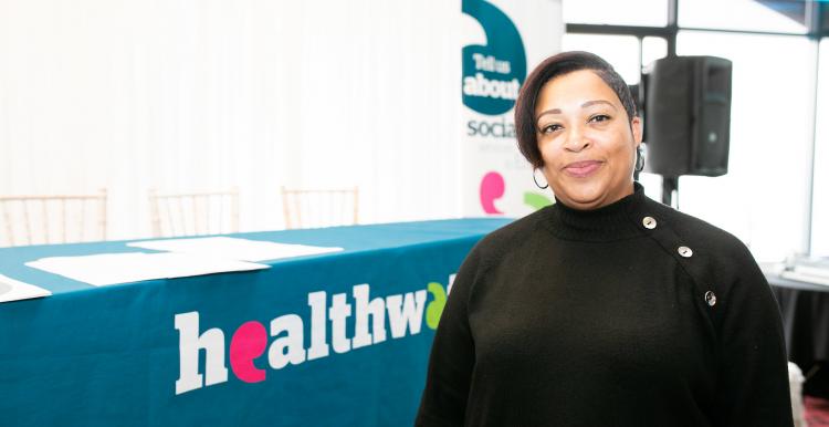 Woman in front of a Healthwatch stand