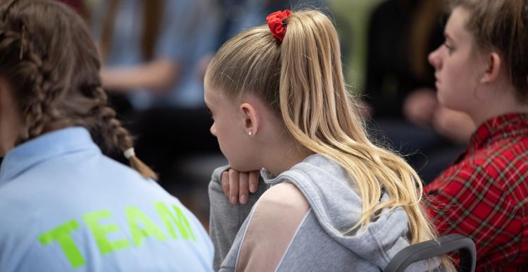 Young girl sat in a row of school children