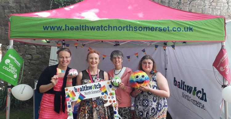 Healthwatch staff standing in front of their stand at the pride event