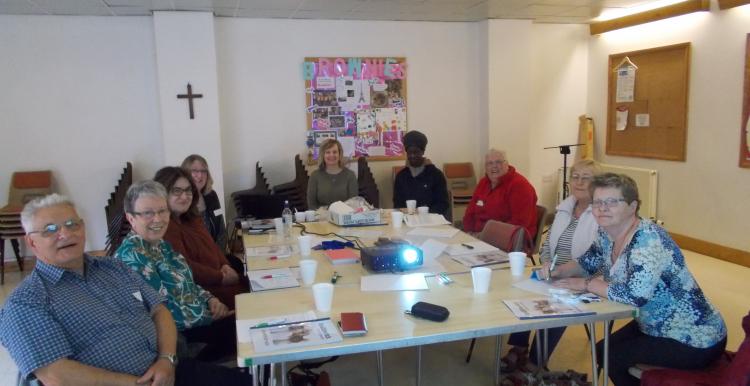 volunteers sat round the table listening to a speech