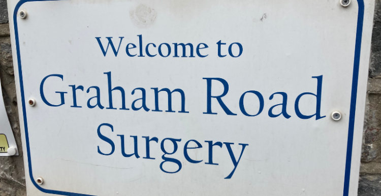 A blue and white sign which reads: 'Welcome to Graham Road Surgery'