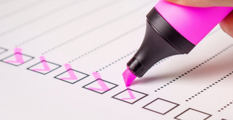 A pink highlighter being used to tick boxes on a list