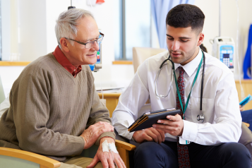 A doctor showing a patient some information on a tablet.