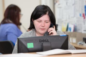 nurse on the phone at the GP centre