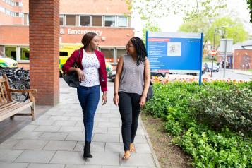 Two women walking into a hospital together