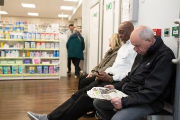 Patients sat waiting in a pharmacy