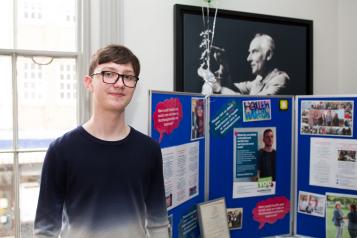 Young volunteer standing in front of Healthwatch display boards