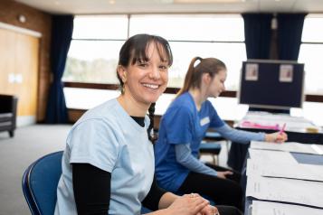 Two nurses sat at a desk