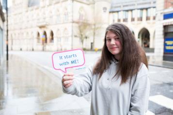 Teenage girl holding up a sign