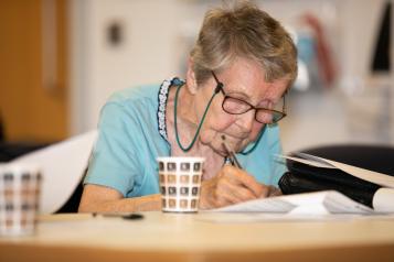 Elderly woman filling in a form