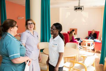 Three nurses talking on a hospital ward