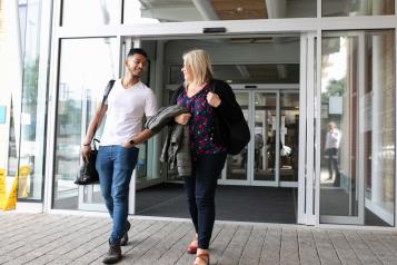 Man and woman walking out of a hospital