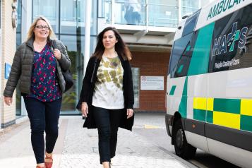 Two women walking into a hospital together