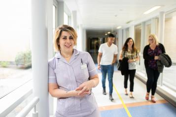 Nurse standing in a busy corridor