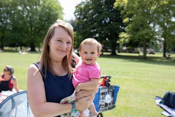 Mum at a breastfeeding picnic with her baby in her arms