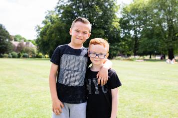 Two young boys standing with their arm round each other