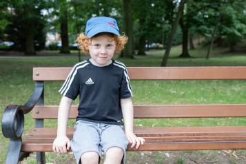 Young boy sitting on a park bench
