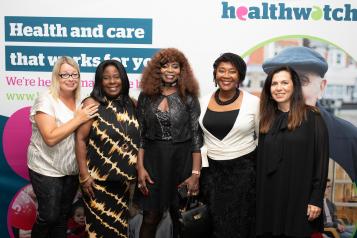 Women at a Healthwatch event, smiling for the camera