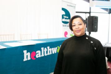Woman in front of a Healthwatch stand