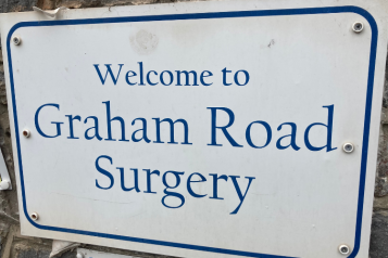 A blue and white sign which reads: 'Welcome to Graham Road Surgery'