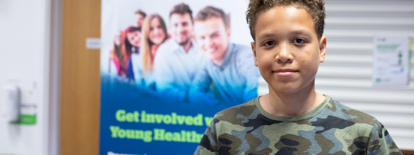Young lad in front of a Healthwatch sign