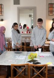 Young people stood around a desk on a workshop