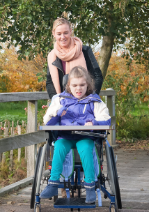 A woman pushing a young girl in a wheelchair